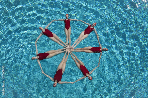 Elevated view of synchronised swimmers forming a circle in pool