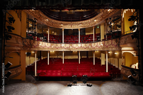 View of an empty theatre with red seats and balcony photo