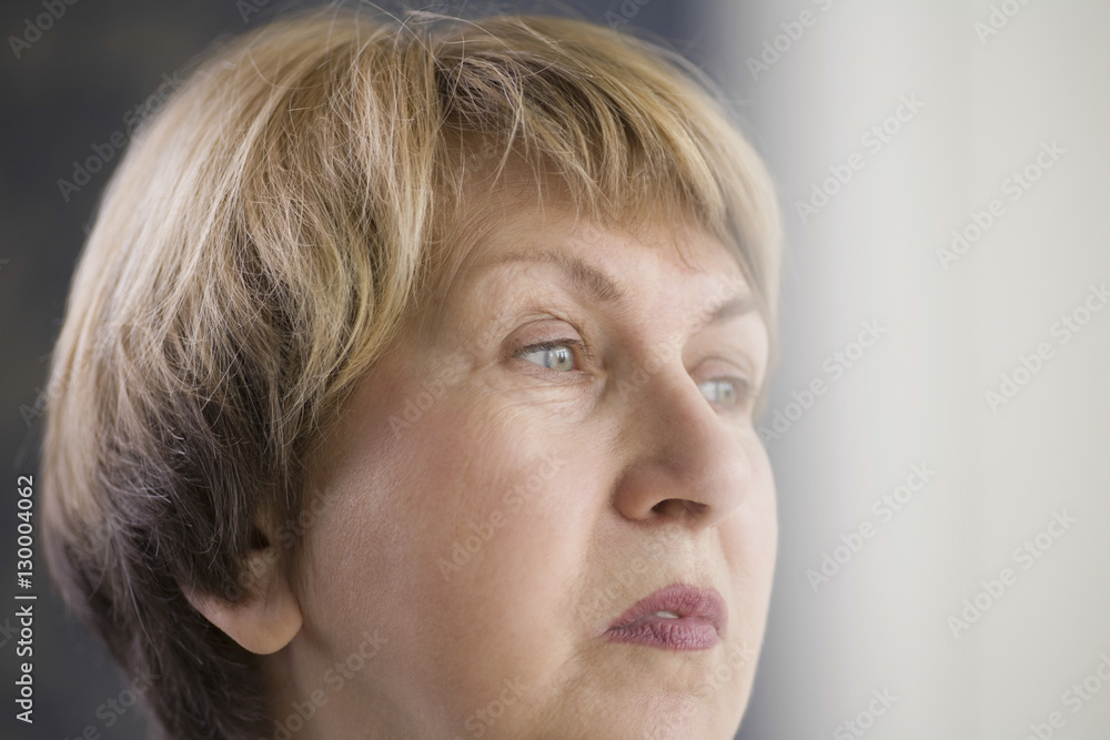 Closeup of pensive senior woman looking away at home Closeup of pensive senior woman looking away at home