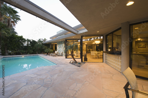 View of swimming pool and illuminated modern home exterior