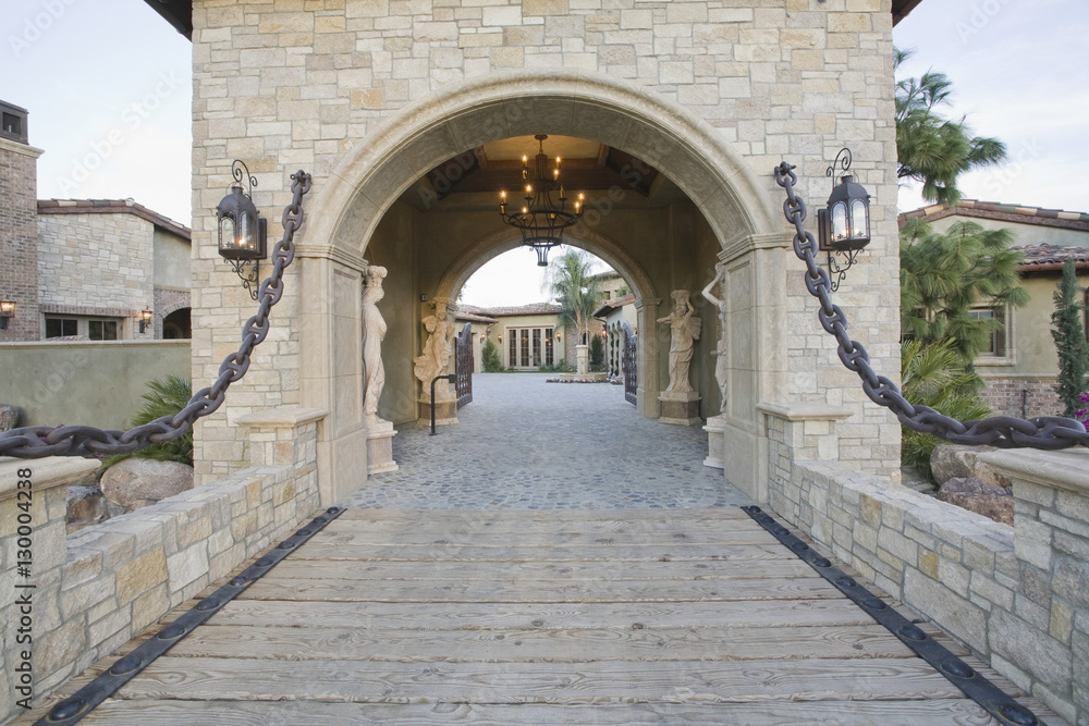 Stone gateway with arched structure to modern home Stone gateway with arched structure to modern home