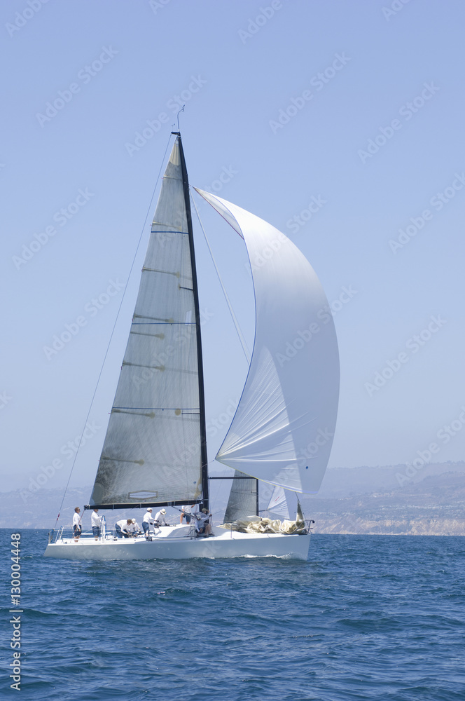 Fototapeta premium Sailboat racing in the blue and calm ocean against sky