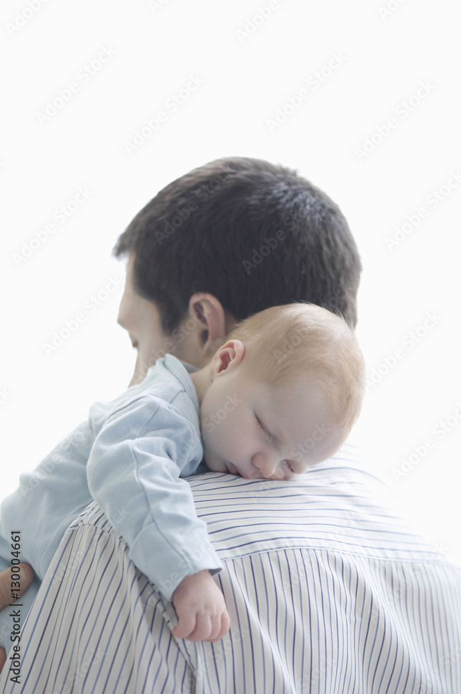Newborn baby sleeping on father's shoulder over white background Newborn baby sleeping on father's shoulder over white background