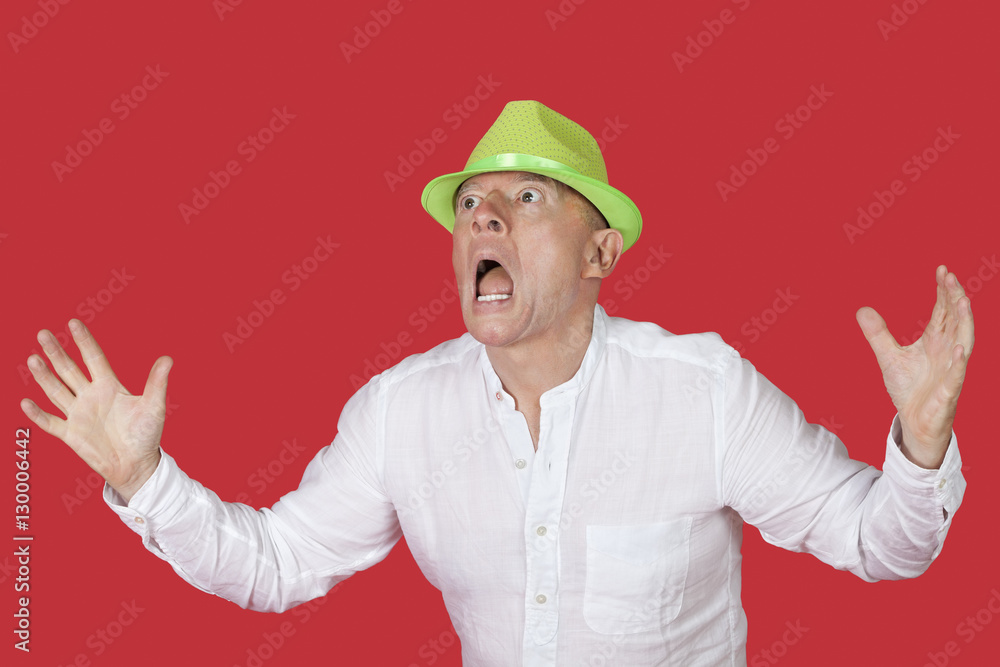 Portrait of an shocked man screaming against red background Portrait of an shocked man screaming against red background