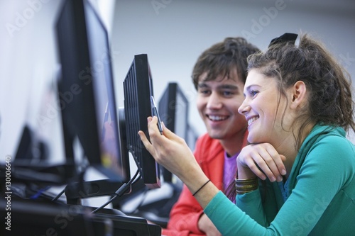 фотографія Side view of two young university students using computers