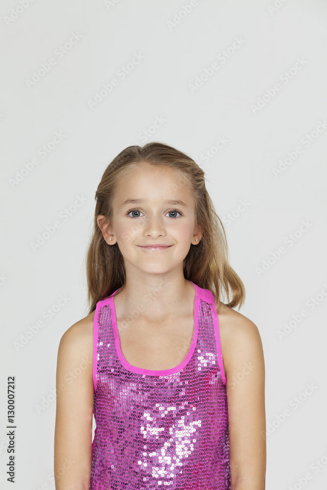 Portrait of young girl smiling against gray background Portrait of young girl smiling against gray background