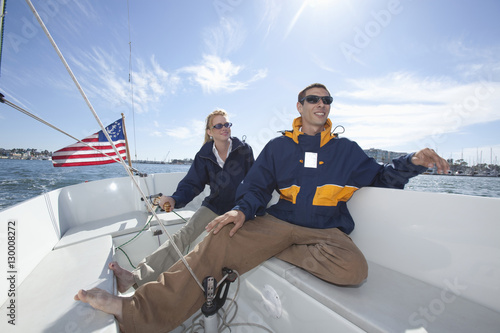 Young interracial couple relaxing on deck of sailing boat