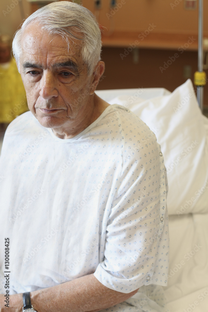 Upset elderly man sitting on hospital bed Upset elderly man sitting on hospital bed