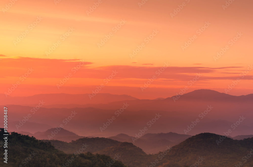 Orange and pink twilight sunset with layers of mountains silhou Orange and pink twilight sunset with layers of mountains silhou