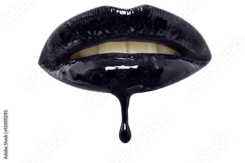 Close-up of black lip-gloss dripping from woman's lips over white background