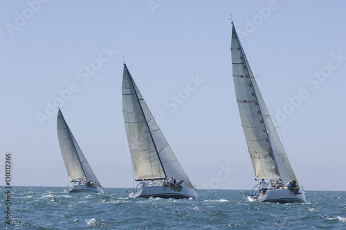 View of three yachts compete in team sailing event