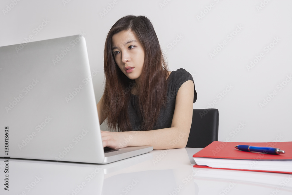 Fototapeta premium Young businesswoman using laptop in office