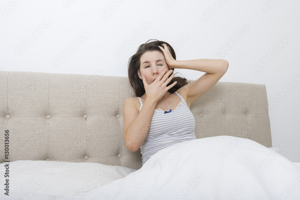 Sleepy woman yawning in bed Sleepy woman yawning in bed