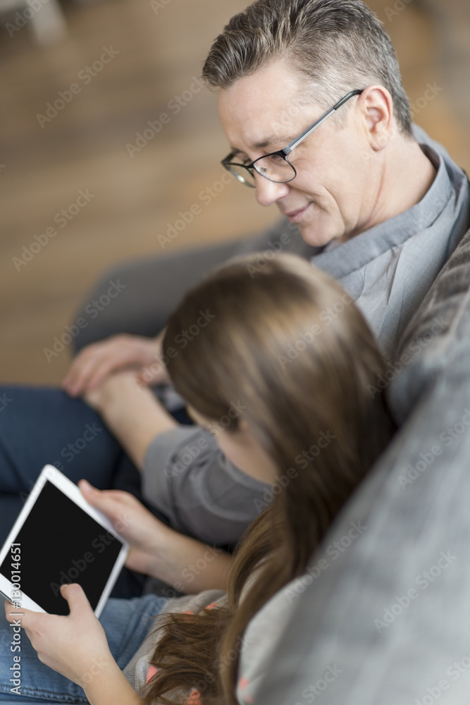High angle view of father and daughter using digital tablet at home