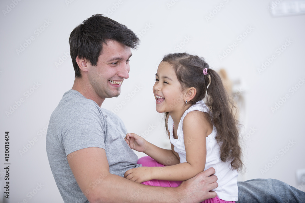 Side view of playful father and daughter at home Side view of playful father and daughter at home