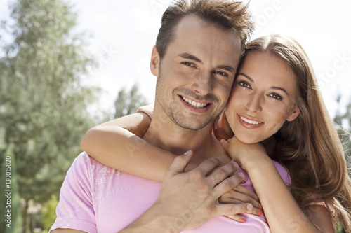 Portrait of beautiful young woman embracing man in park © moodboard