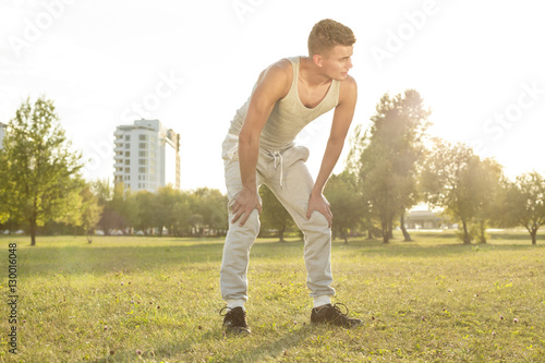 Full length of tired young man standing in park after jogging