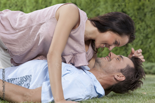 Side view of loving woman lying on man in park