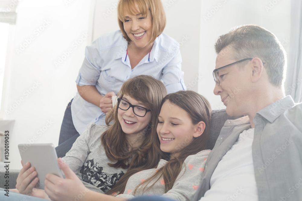 Fototapeta premium Happy family using tablet PC on sofa at home