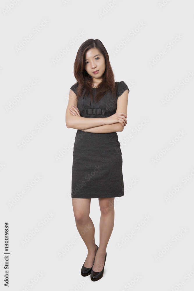 Full length portrait of beautiful young businesswoman standing arms crossed over white background Full length portrait of beautiful young businesswoman standing arms crossed over white background