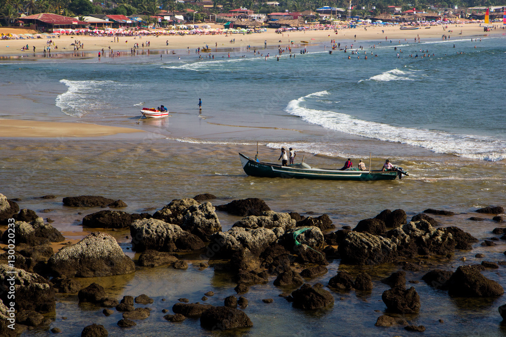 Obraz premium Boats on the beach Arambol, tourists and entertainment