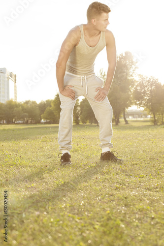 Full length of tired man standing in park after jogging