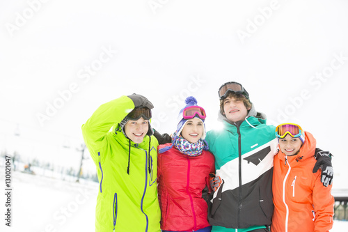 Portrait of young friends standing together in snow