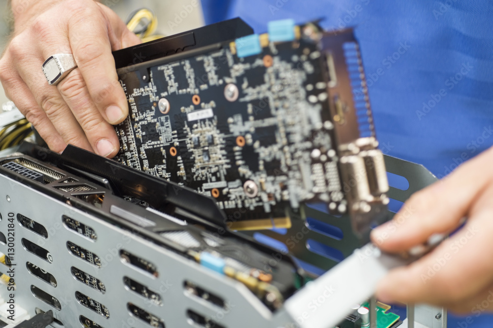 Cropped image of male engineer repairing video card in computer manufacturing industry Cropped image of male engineer repairing video card in computer manufacturing industry