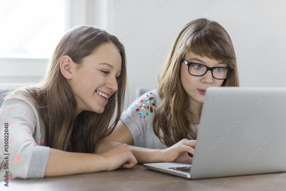 Sisters using laptop together at home Sisters using laptop together at home
