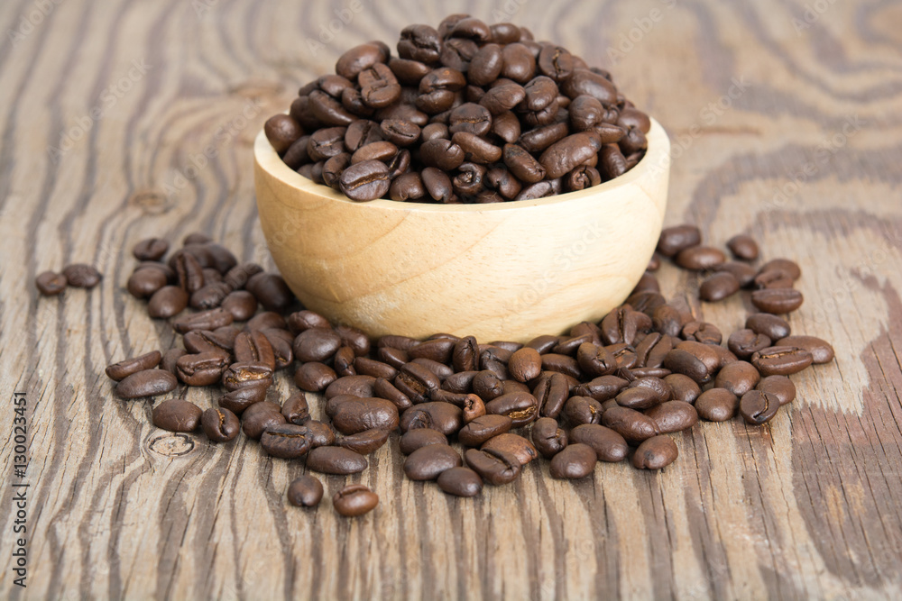 Coffee beans in wood spoon and on old wood table Coffee beans in wood spoon and on old wood table