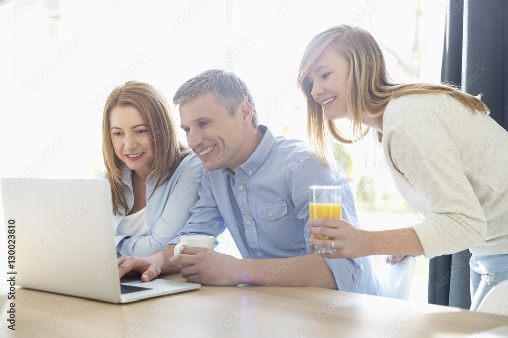 Happy parents with daughter using laptop at home Happy parents with daughter using laptop at home