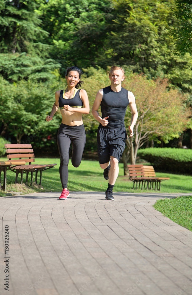 Multi ethnic couple running in park
