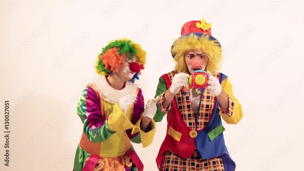 A couple of glad funny clowns playing and singing, when the toy frightens them A couple of glad funny clowns playing and singing, when the toy frightens them
