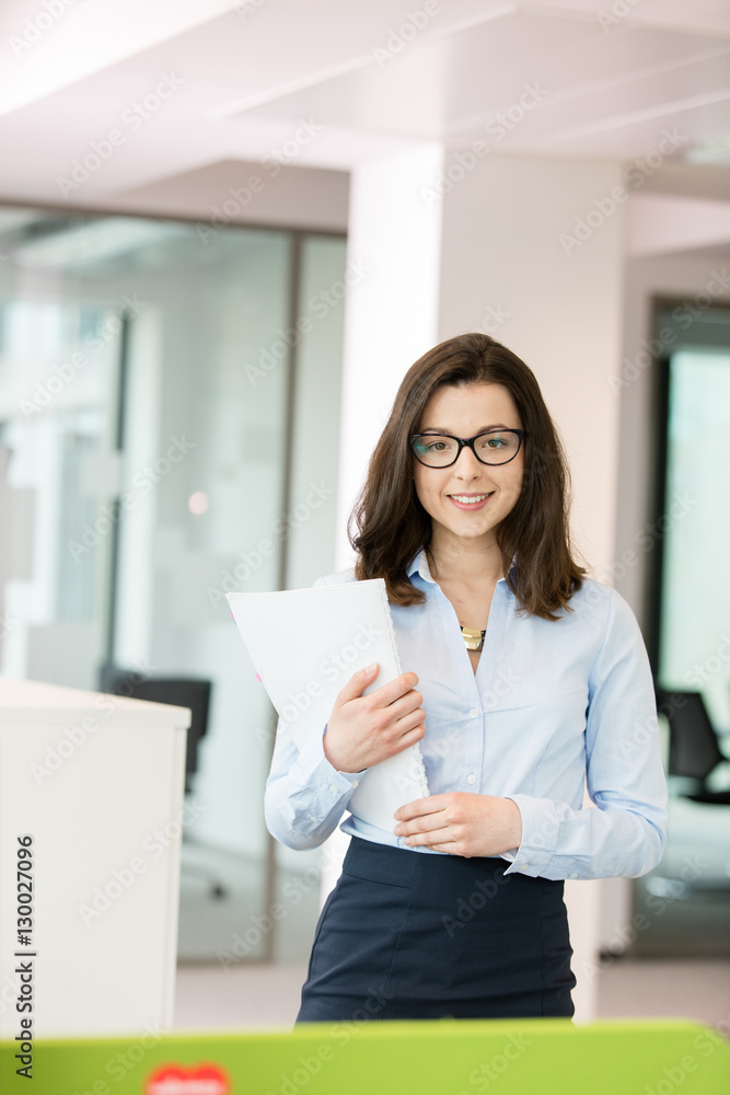 Portrait beautiful young businesswoman holding spiral book in office Portrait beautiful young businesswoman holding spiral book in office