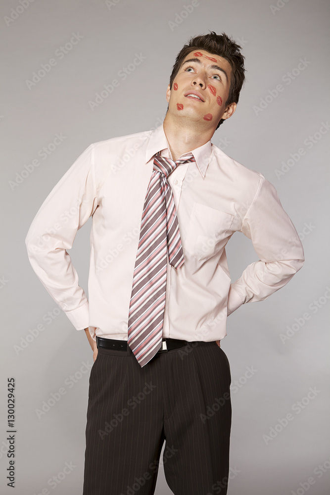 Young caucasian businessman with lipstick kiss mark on his cheek Young caucasian businessman with lipstick kiss mark on his cheek