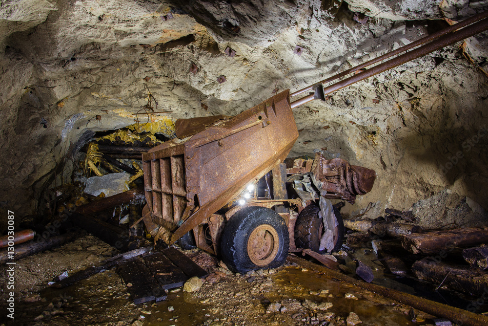Fototapeta premium Abandoned old ore mine shaft tunnel passage loading machine