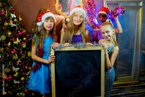 Group of young girls celebrating Christmas. Black board