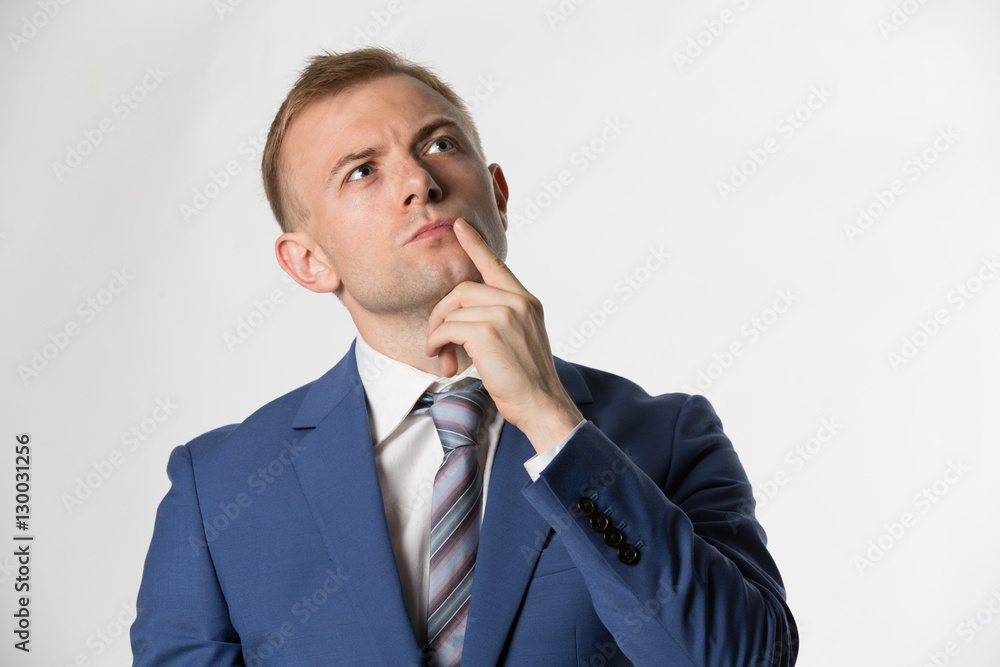 Businessman with finger on face thinking Businessman with finger on face thinking