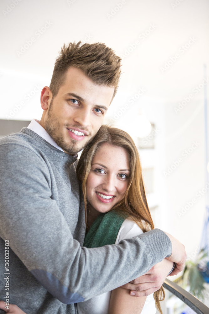 Fototapeta premium Portrait of loving young man hugging woman at cafe