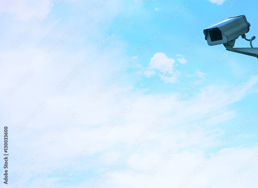 Security camera on wall against clouds Security camera on wall against clouds