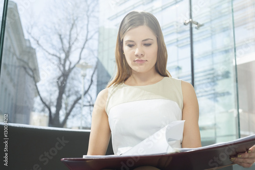 Businesswoman reading file in office Free Download Businesswoman reading file in office - GFXLoad