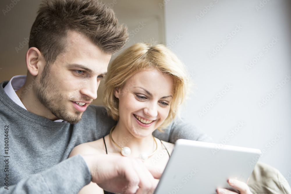 Happy young couple using digital tablet in cafe Happy young couple using digital tablet in cafe