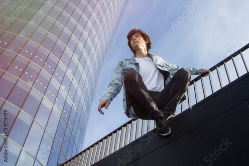 Young man doing parkour in the city against skyscraper