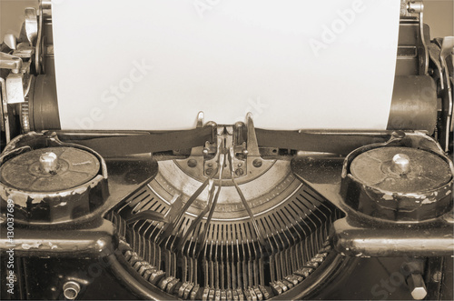 Old typing machine and blank sheet of paper for your text, sepia style photo