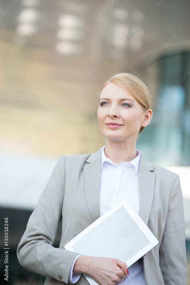 Confident businesswoman holding digital tablet outdoors Confident businesswoman holding digital tablet outdoors