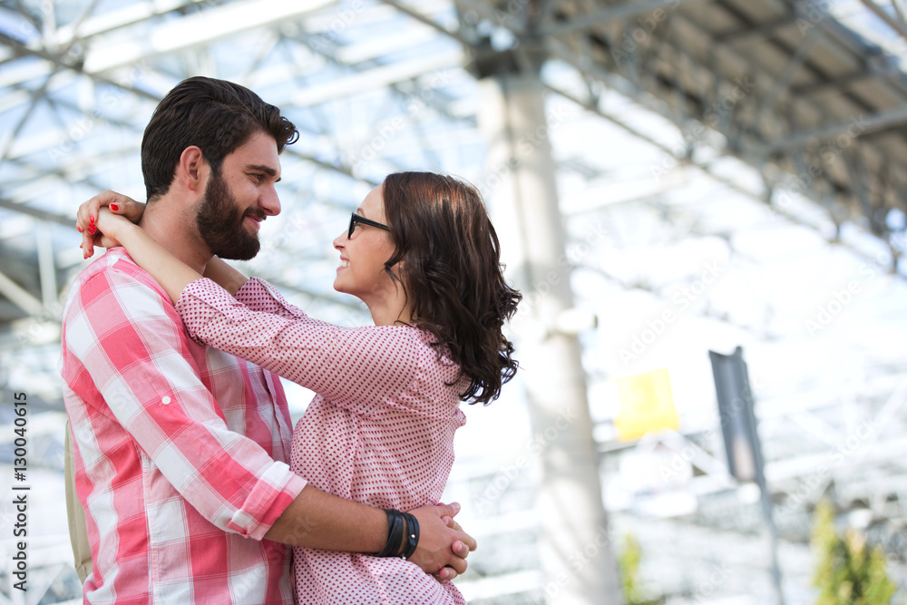 Fototapeta premium Loving couple looking at each other while embracing outside building