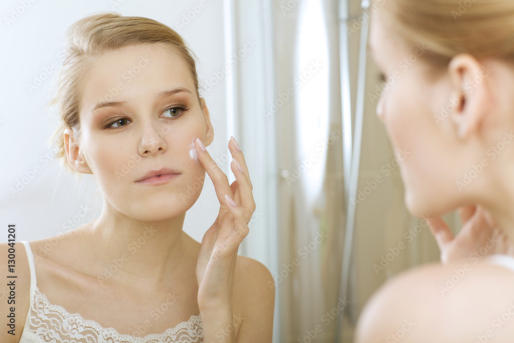 Young woman applying beauty cream, close up Young woman applying beauty cream, close up