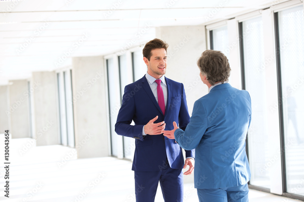 Young businessman talking with male colleague in new office Young businessman talking with male colleague in new office