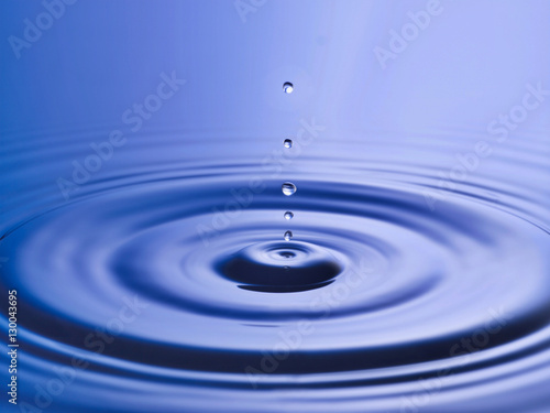 Drop hitting surface of water close-up