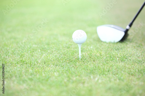 Close-up of golf club and tee with ball on grass
